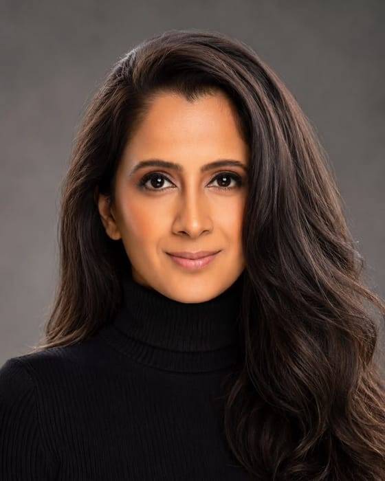 Namrata Rattan, photographed from the shoulders up against a plain wall.